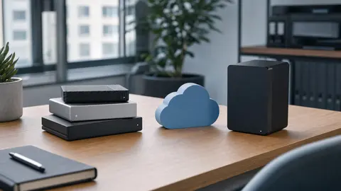 Backup-Konzept auf einem Schreibtisch: mehrere externe Speichermedien und ein Cloud-Symbol als drei redundante Datenkopien